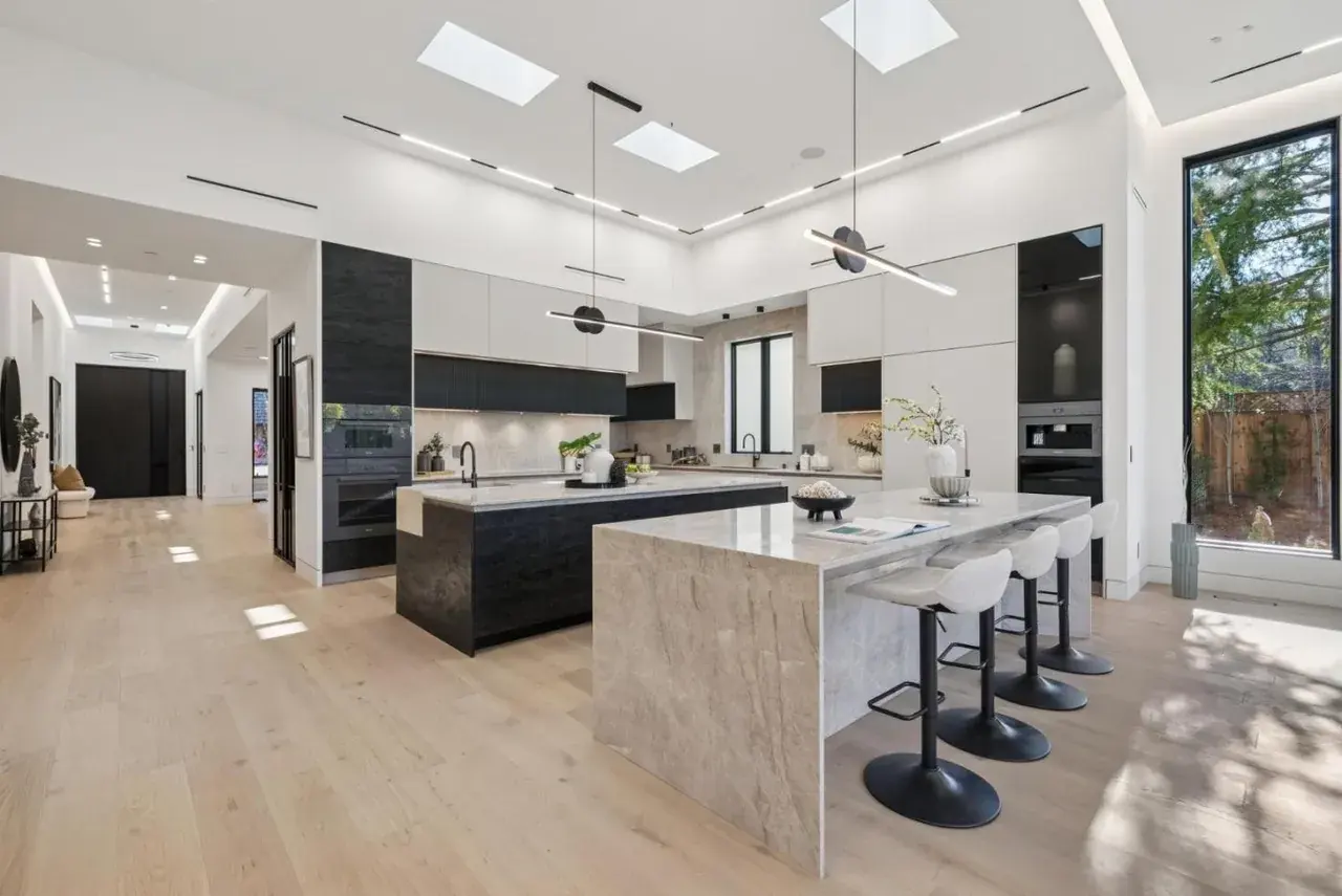 Kitchen with skylights, a linear pendant over the island and a lit perimeter cove