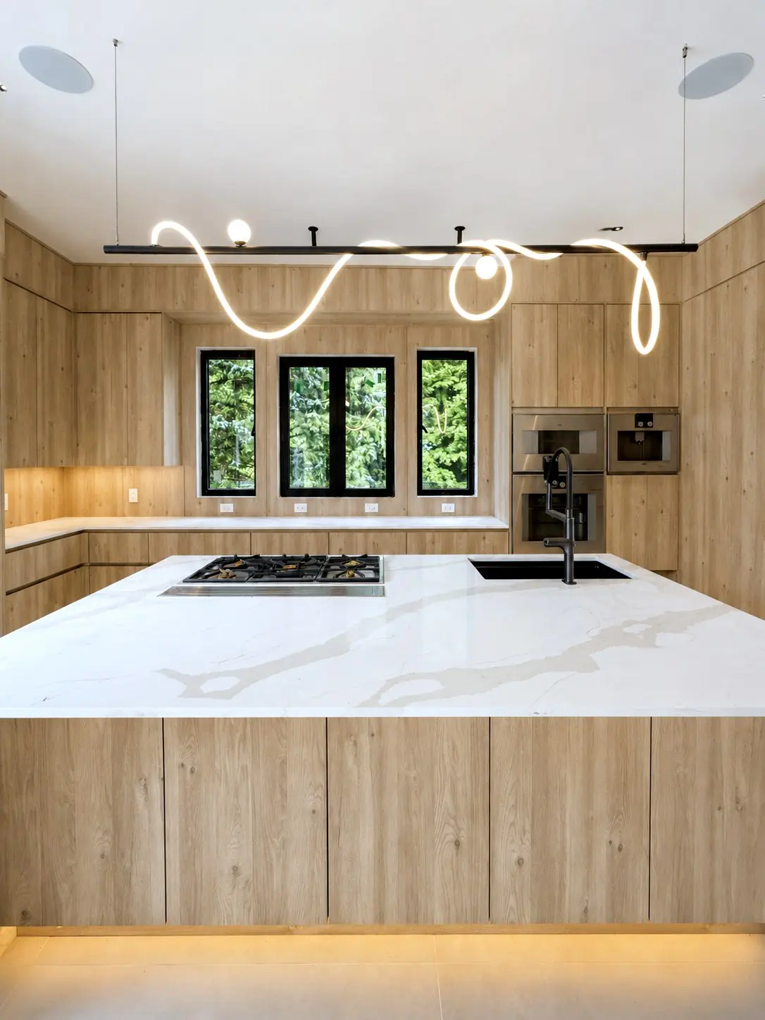 Kitchen island under two looping light pendants