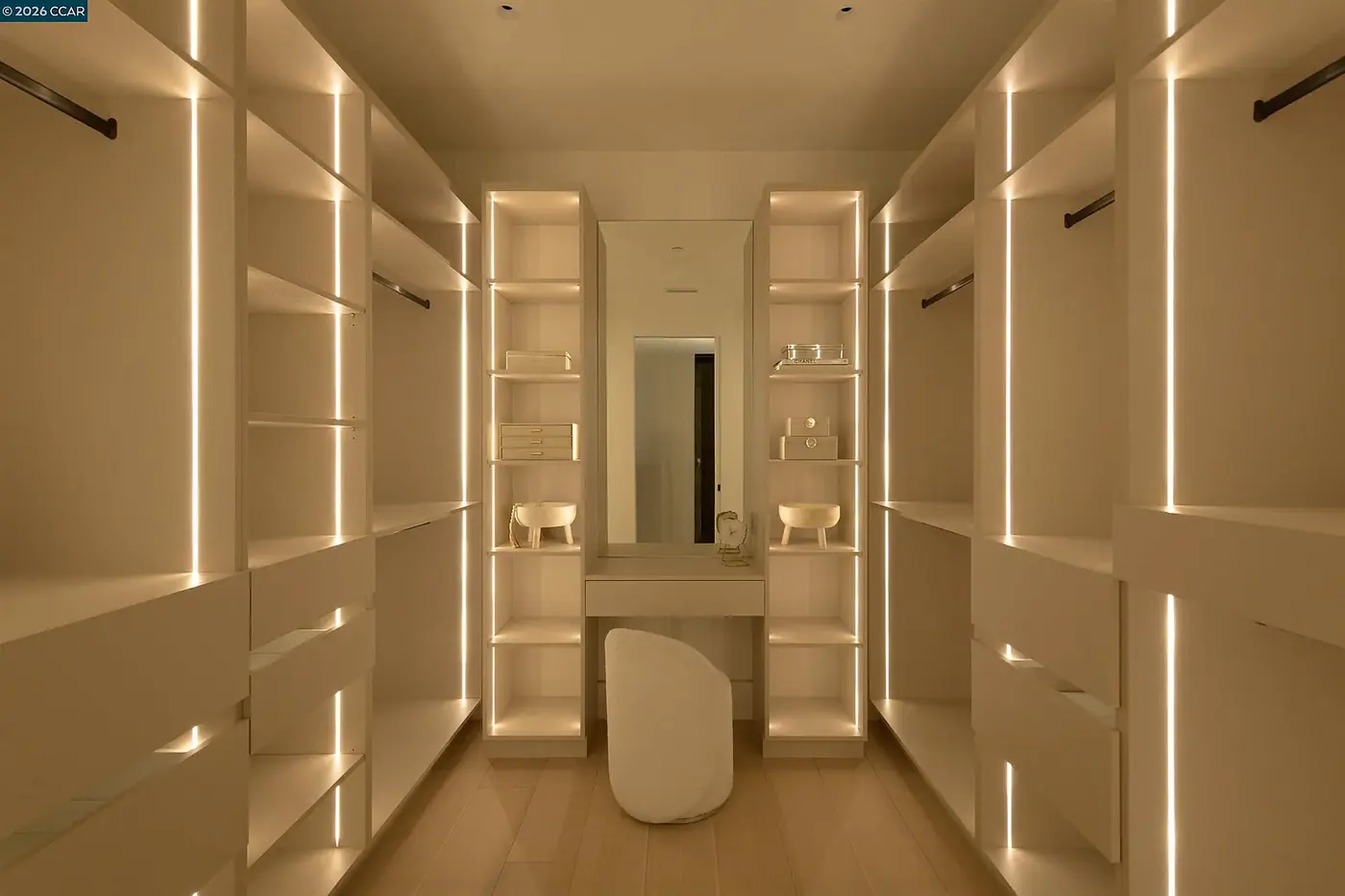 Dressing room lit by vertical LED strips between the cabinetry