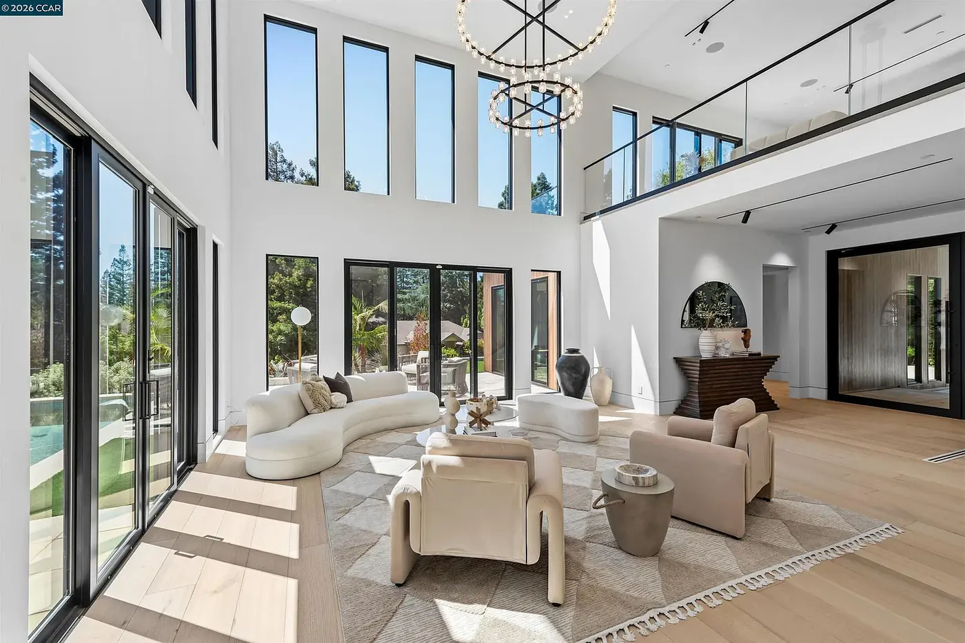 Living room with a ring chandelier and full height glazing