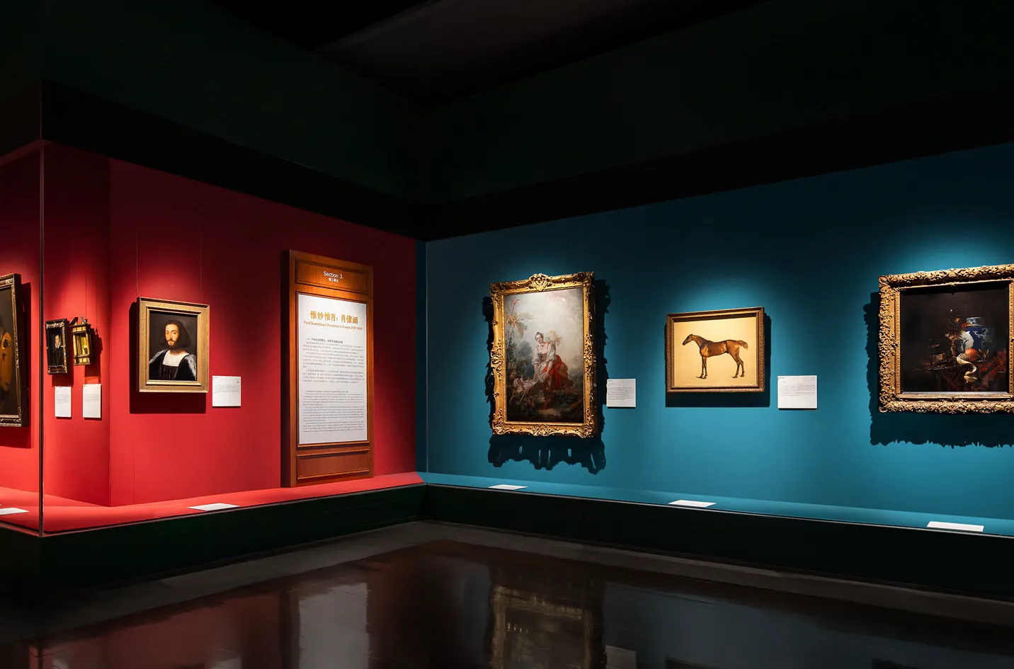 Paintings picked out of dark gallery walls by narrow beam track spots