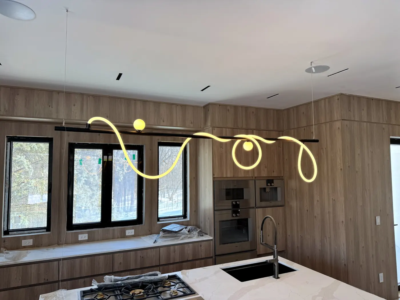 Kitchen with a looping light pendant above the cooktop