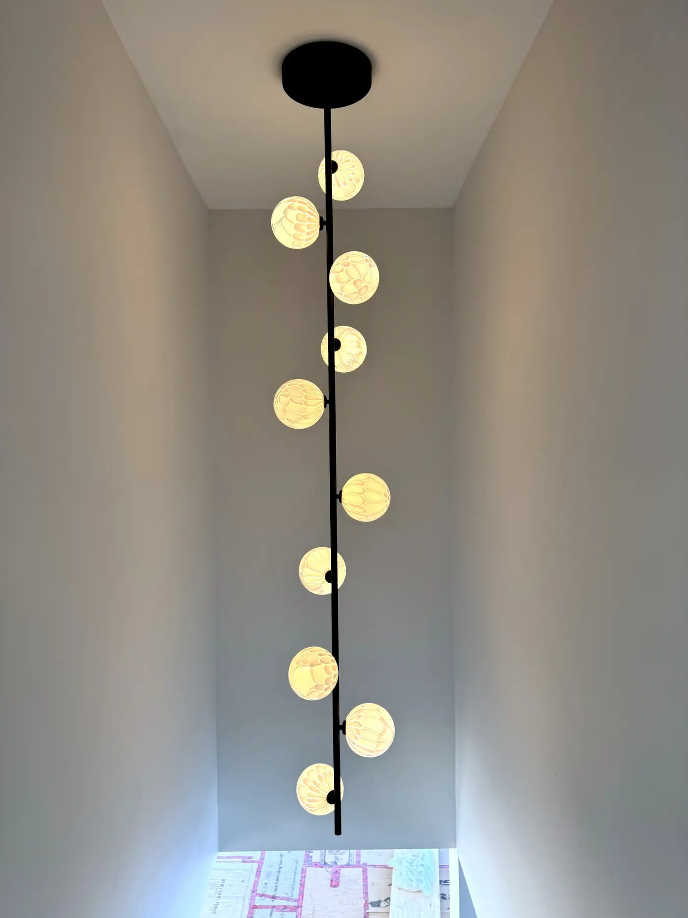 Cascade of globe pendants dropping through a stairwell