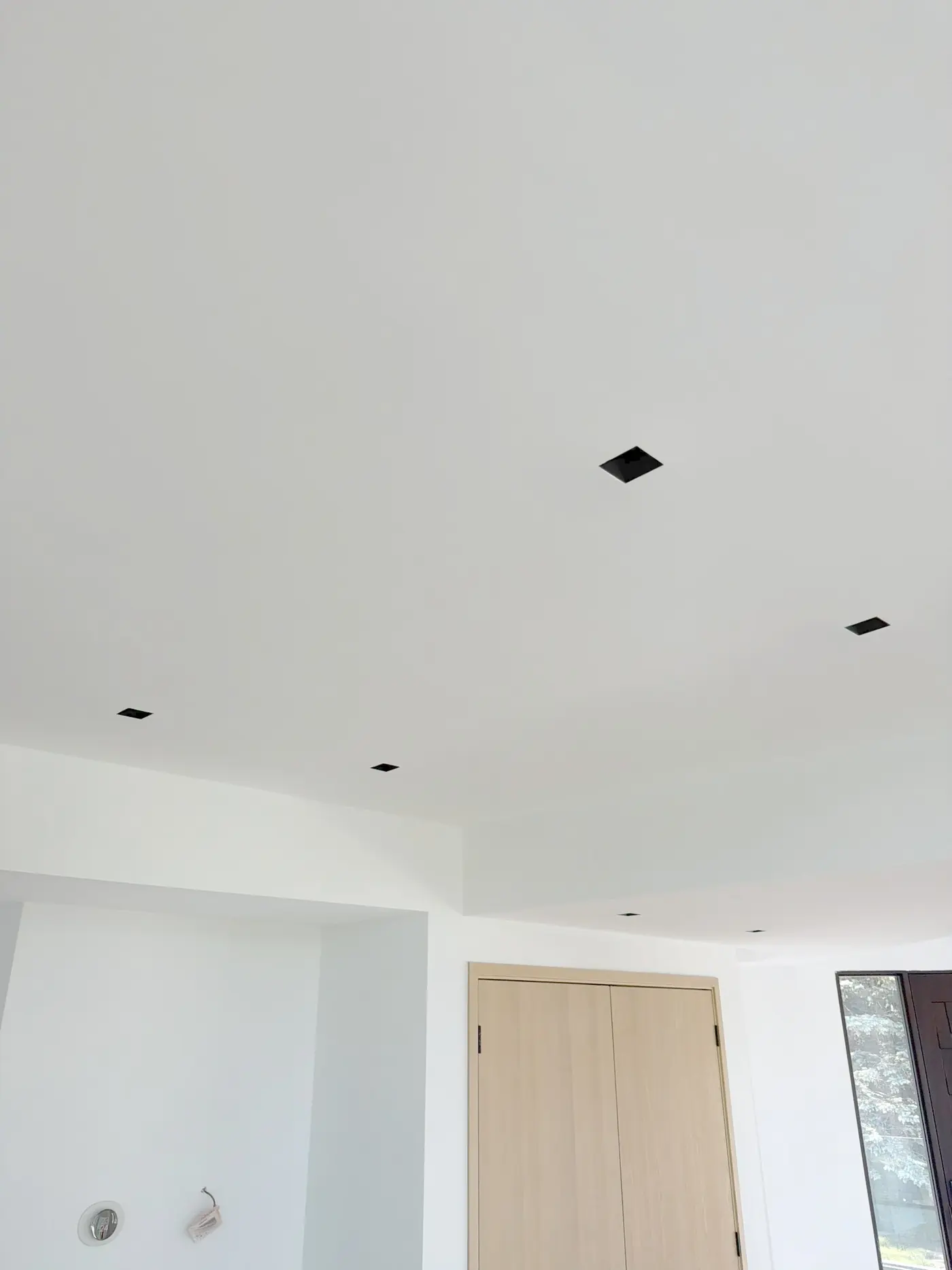 Recessed downlights set flush into a plaster ceiling